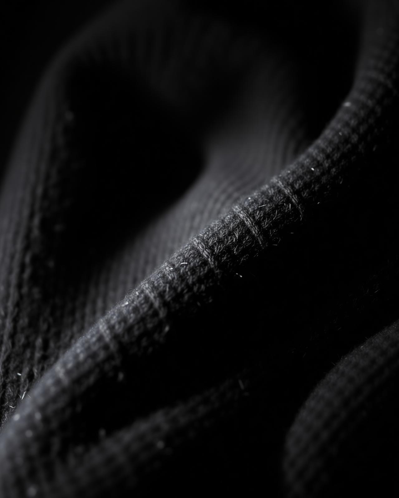 Macro detail of heavy black French Terry cotton fabric showing weave texture.